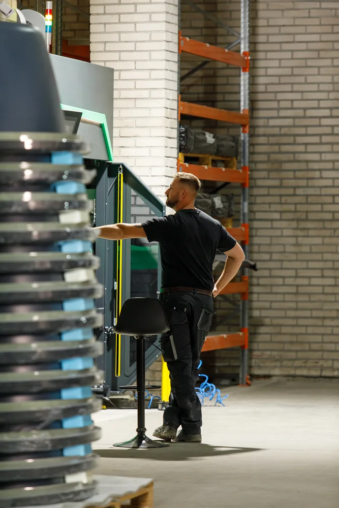 Pracownik AkrylTech przy wkładach akrylowych ułożonych w magazynie